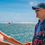 A woman and a man holding hands while glancing at the ocean view, showing intimate vacation experiences in Belize.