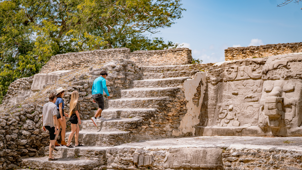 Travelers climbing the temple at Cerros in Corozal District, Belize